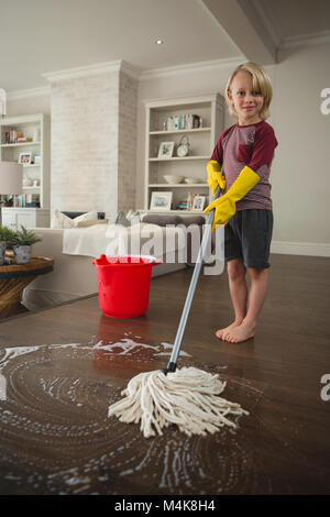 Boy washing the floor with mop Stock Photo