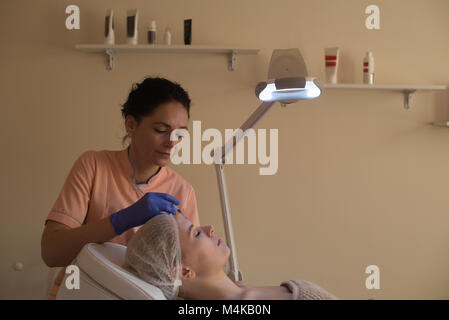Beautician giving beauty treatment to female customer Stock Photo