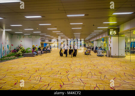 SINGAPORE, SINGAPORE - JANUARY 30, 2018: Indoor view of air hostess and pilots walking through the the lounge, inside of the Singapore Changi International Airport Stock Photo