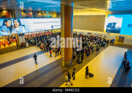 SINGAPORE, SINGAPORE - JANUARY 30, 2018: Above view of crowd of people waiting in queue at arrival immigration of Changi airport. Changi International Airport serves more than 100 airlines operating 6,100 weekly flights Stock Photo