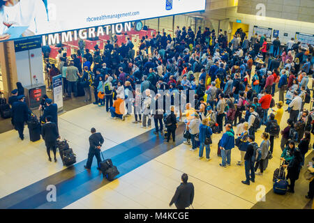 SINGAPORE, SINGAPORE - JANUARY 30, 2018: Above view of crowd of people waiting in queue at arrival immigration of Changi airport. Changi International Airport serves more than 100 airlines operating 6,100 weekly flights Stock Photo