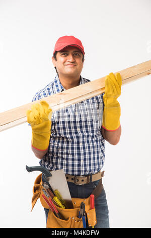 Handsome Indian Carpenter or wood worker in action, isolated over white background Stock Photo