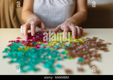 Woman hand sorting car electric parts colorful mini fuses on desk. Soft focus. Stock Photo