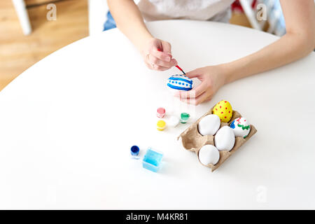 Woman's hand painting eggs for Easter Stock Photo