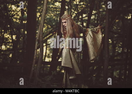 Elfin lady walking in the forest. Fantasy and fairy Stock Photo