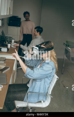 Female executive using virtual reality headset Stock Photo
