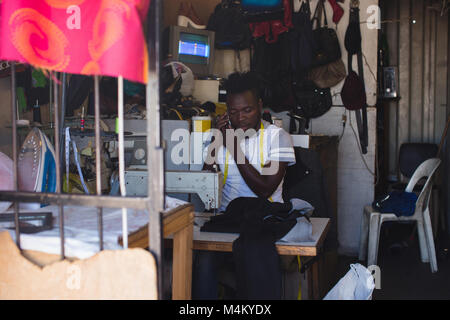 Tailor talking on mobile phone Stock Photo