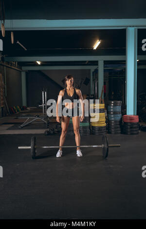 Fit woman ready to lift the barbell Stock Photo