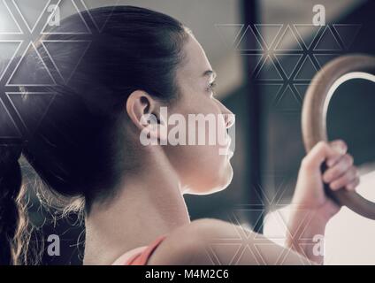 Athletic fit woman in gym using rings with triangle interface Stock Photo