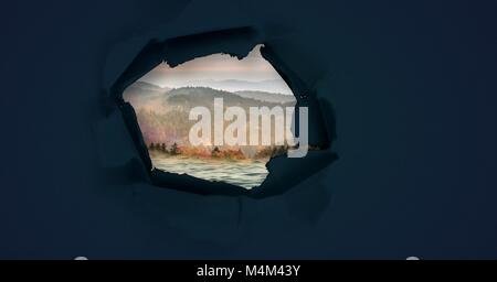 Nature landscape through surreal paper hole Stock Photo