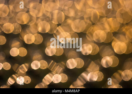 Golden sparkles from shiny patterned surface Stock Photo