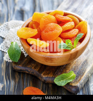 Dried apricots in wooden bowl. Stock Photo
