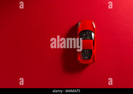 Red toy sports car on a red background. Stock Photo