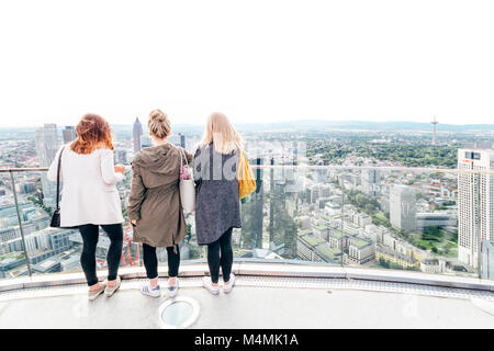 Tourist girls enjoying the beautiful skyline view on a sunny saturday afternoon from the top of Main Tower, Frankfurt am Main / Germany - May 20 2017