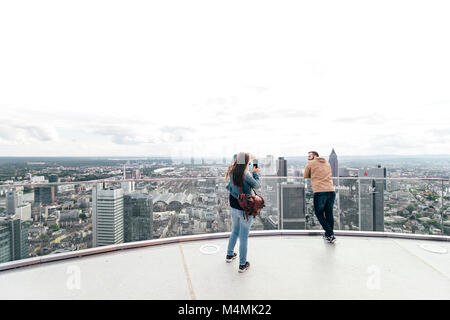Tourist couple taking photos on a sunny Saturday afternoon from the top of Main Tower Frankfurt / Germany - May 20 2017 Stock Photo