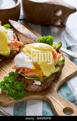 Eggs benedict, scandinavian style - with avocado and poached salmon. Stock Photo