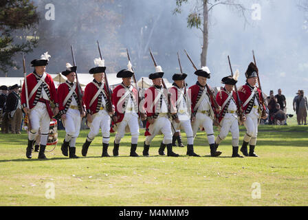 British redcoat soldiers marching across the batttlefield   during a reenactment of the American revolution  in  Huntington Beach California USA Stock Photo