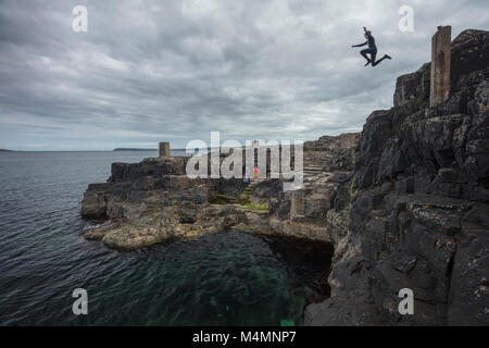 Cliff jumping into the Blue Pool, Portrush, County Antrim, Northern Ireland. Stock Photo