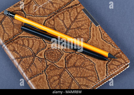 notebooks in leather covers and a pencil close up Stock Photo
