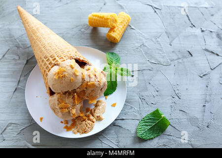 Caramel ice cream in a waffle cone. Stock Photo