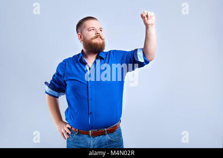 A fat, bearded man writes his hand . Stock Photo
