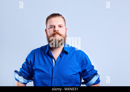 A fat, bearded man looks  with a serious expression of emotion. Stock Photo