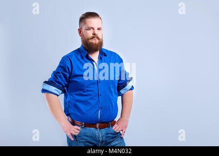 A fat, bearded man looks  with a serious expression of emotion. Stock Photo