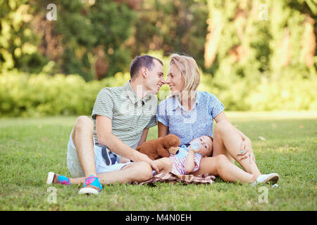 Happy family on the grass in park playing with their dog Stock Photo ...