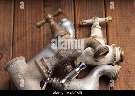 plumber tool faucet for house repair lying on wooden background Stock Photo