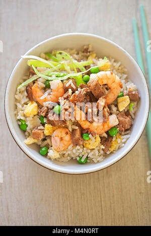 Fried rice with char sui pork, prawns, egg and vegetables with sesame oil Stock Photo