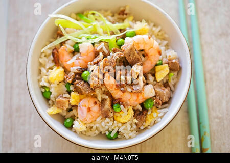 Fried rice with char sui pork, prawns, egg and vegetables with sesame oil Stock Photo