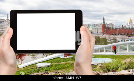 travel concept - tourist photographs Zaryadye urban park and Kremlin Walls on embankment in Moscow city in autumn on tablet with cut out screen for ad Stock Photo