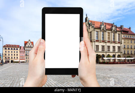 travel concept - tourist photographs main Market Square (Rynek) in Wroclaw city in Poland in autumn morning on tablet with cut out screen for advertis Stock Photo