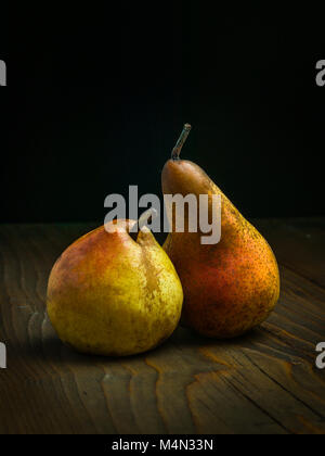 Juicy ripe pears on the wooden table. black background Stock Photo