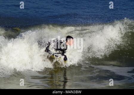 Daring Male Bodyboarder Surfing the Cold North Sea Waves at Aberdeen Beach, Scotland, UK. Winter 2018. Stock Photo