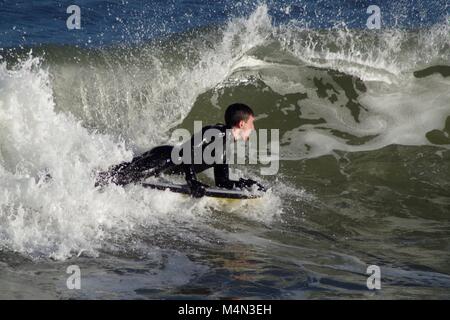 Daring Male Bodyboarder Surfing the Cold North Sea Waves at Aberdeen Beach, Scotland, UK. Winter 2018. Stock Photo