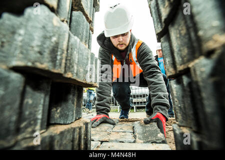 Apprentice learning how to lay bricks Stock Photo