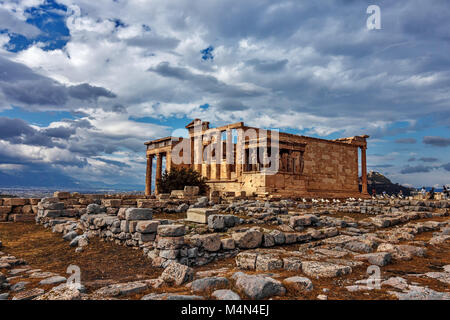 View on the temple which is illuminated by the sun rays, falling through the rain clouds.The temple Erechtheion is known by its columns as caryatids.  Stock Photo