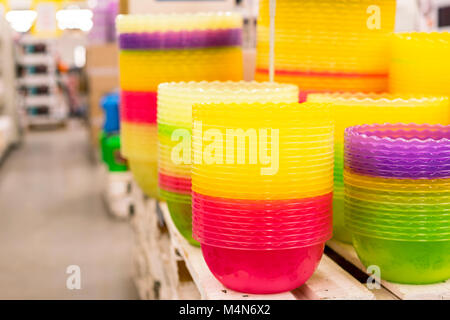 Plastic multi-colored bowls on the shelf in the store. Stock Photo