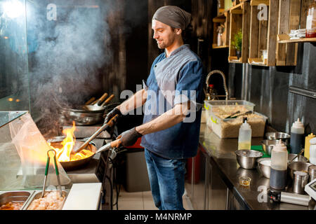 Chief cook cooking at the asian kitchen Stock Photo