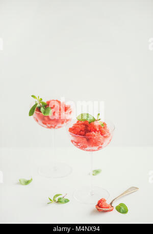 Healthy low calorie summer treat. Strawberry and champaigne granita or shaved ice dessert with fresh mint in champaigne glasses, white background, cop Stock Photo