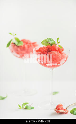 Healthy low calorie summer treat. Strawberry and champaigne granita or shaved ice dessert with mint in champaigne glasses, white background, copy spac Stock Photo