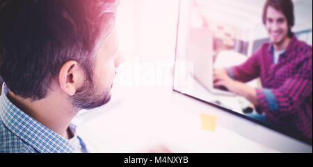 Composite image of graphic designer using laptop at his desk Stock Photo