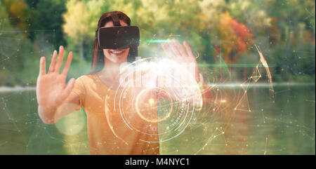 Composite image of happy young woman gesturing while using virtual reality glasses Stock Photo