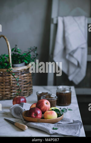 Apple jam and fresh apples on a rustic kitchen table Stock Photo