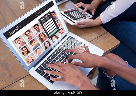 Composite image of executives using digital tablet and laptop at table Stock Photo