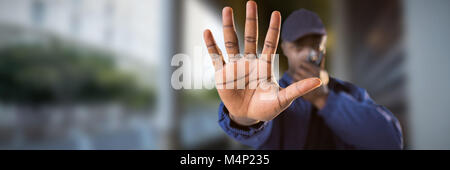 Composite image of confident security talking on walkie talkie and making stop gesture Stock Photo