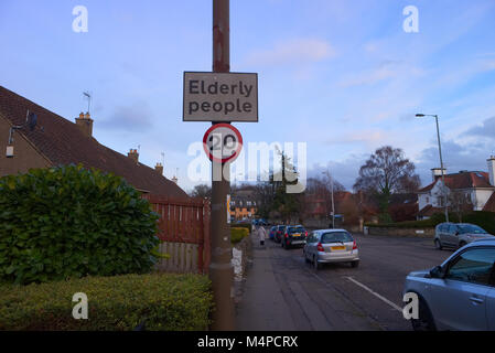 A sign showing a 20 mile an hour speed limit and to be aware of elderly people in the area. Stock Photo