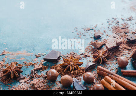 Dessert ingredients flat lay. Chunks of milk and bitter chocolate, spices and scattered cocoa on a stone background. Confectionery food photography. Stock Photo