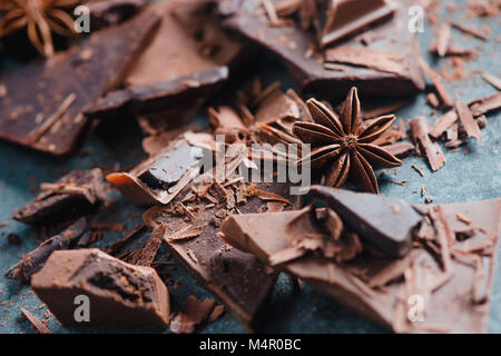 Cooking desserts and home concept. Chocolate pieces, spices, anise stars, cinnamon and cocoa on a stone background. Ingredients close-up. Stock Photo